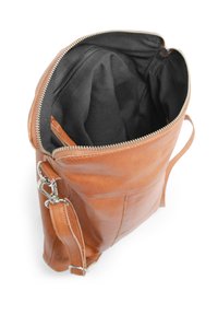 Sac à main en cuir marron avec fermeture éclair, doté d'un intérieur spacieux en tissu noir et d'une bandoulière ajustable. Texture lisse et design épuré.