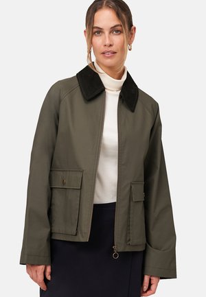 Veste vert olive en tissu lisse, dotée d'un col en velours noir, d'une fermeture éclair à l'avant et de deux poches avant avec des fermetures à bouton.