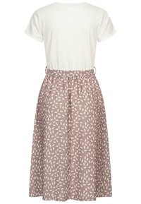 Robe à manches courtes avec un haut blanc et une jupe grise ornée d'un léger motif de feuilles. La jupe a une taille élastique et un design fluide.