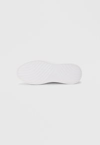 Talpa de adidasi albi cu striuri texturate și margine netedă, având o amprentă a logo-ului și un design curat fără branding vizibil.