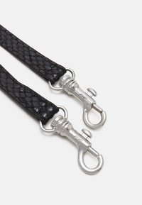 Sangle noire tressée avec une texture brillante, dotée de clips et de quincaillerie en métal argenté, mettant en valeur un design épuré et moderne.