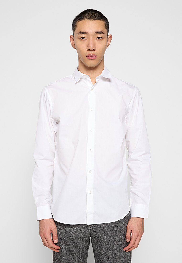 Witte blouse met lange mouwen van zachte katoen. Kenmerkt zich door een klassieke kraag, knoopsluiting aan de voorkant en een rechte zoom met iets aangesloten mouwen.