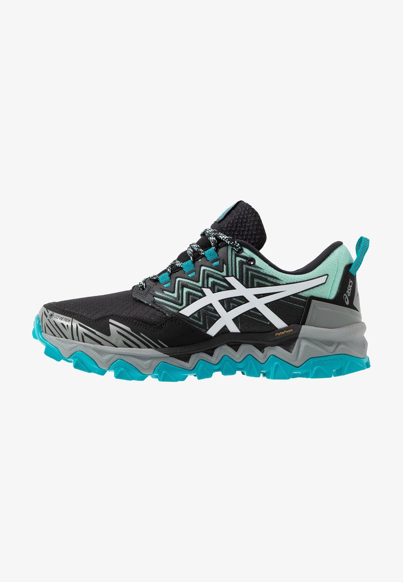 Chaussure de trail running avec un dessus noir à motif géométrique et des accents blancs, semelle turquoise, et intermédiaire texturé pour l'adhérence et le soutien.