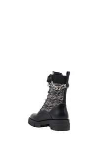 Stivaletti neri alla caviglia con una tomaia in tessuto testurizzato caratterizzata da un motivo con logo, chiusura a lacci frontale e un'accento di catena metallica sul collo. Suola spessa.