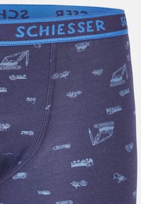 Boxer in blu navy con motivi grafici chiari di veicoli. Presenta un morbido elastico in vita con il logo "SCHIESSER".