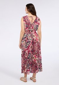 Rochie maxi cu un model geometric colorat în roz, albastru și crem, având un guler cu legare la spate și un design fără mâneci.