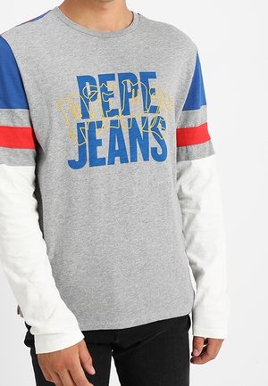Grå langærmet skjorte med blå, rød og hvide detaljer, med "Pepe Jeans" trykt i fed blå og gul skrift.