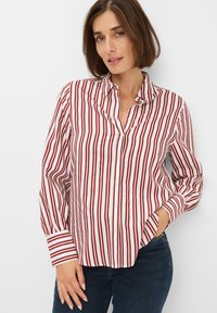 Button-up shirt with red and white vertical stripes, long sleeves with contrasting cuffs, made of lightweight fabric, featuring a relaxed collar.
