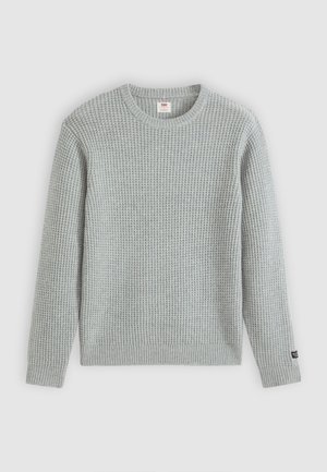 Pull en tricot gris clair avec un motif texturé, col rond et ourlet et poignets côtelés. Comprend un petit logo sur la manche gauche.