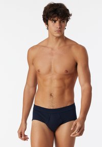 Slip in cotone blu navy con design senza cuciture, dotati di una morbida fascia elastica in vita e una tasca sagomata per il massimo comfort.