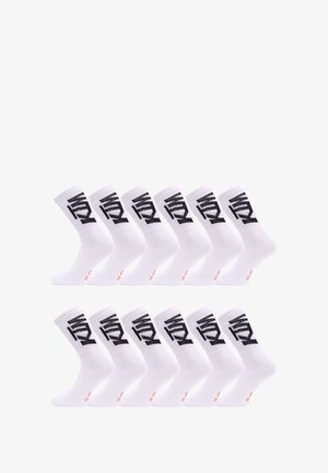 Chaussettes blanches mi-mollet avec un design en texte noir sur le revers, présentant une texture lisse et des accents orange contrastants sur la semelle.