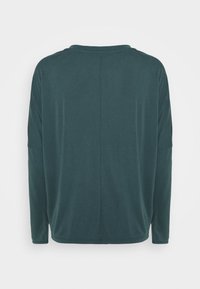 Mörk tealfärgad långärmad t-shirt med rundad halsringning och avslappnad passform. Slät yta med minimal sömnad synlig på baksidan.