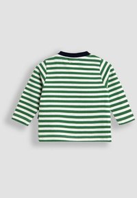 Garā piedurkņu krekls ar mainīgām zaļām un baltām svītrām, apaļu tumši zilu apkakli, kokvilnas materiālu un taisnu apakšmalu ar sānu šķēlumiem.