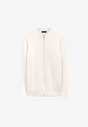 Witte geribbelde gebreide vest met ritssluiting en hoge kraag van textuurstof. Heeft geribbelde boorden en onderkant. Geen zichtbare patronen of accenten.