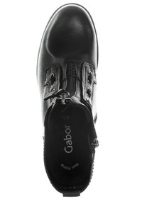 Black leather ankle boot with a round toe, side zipper, and decorative cutouts. Soft interior lining with logo printed on the insole.