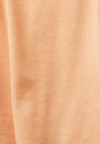 Tejido de color durazno claro con una textura suave, que presenta finas rayas verticales. El material parece elástico y ligero.