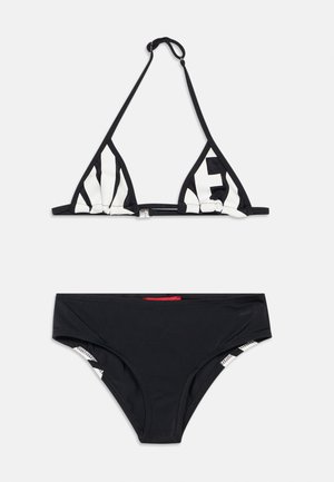 Svart to-delt bikini med trekanttopp med hvite blokkbokstaver og klassiske lavtliggende truser.