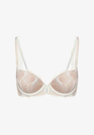 Półprzezroczysty beżowy biustonosz z białą koronką w kwiatowy wzór, miseczkami na fiszbinach i regulowanymi ramiączkami na białym tle.