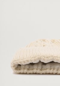 Kootud kreemjas beanie, millel on soonikkoes, volditud äärega ja pehme, luksuslik sisemus sooja ja mugavuse jaoks.