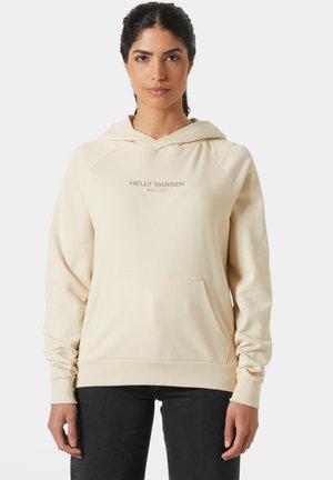 Beżowa bluza z kapturem z kieszenią z przodu, z napisem "HELly HANSEN 1877" w jasnoszarym kolorze. Miękka tkanina z ściągaczami przy rękawach i dolnej części.