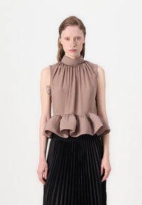 Brūns peplum tops ar augstu apkakli un savilkuma detaļām. Mīksta auduma plūstoša tekstūra, kopā ar melnu pleitu svārku.
