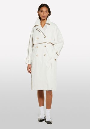 Trench-coat blanc à double boutonnage avec de grands boutons, un large col et des poches latérales. Tissu lisse avec une silhouette légèrement structurée.