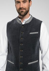 Dunkelgraue Cordweste mit einem runden Kragen, Messingknöpfen, grauen Akzenten an den Taschen und einem klassischen Design.