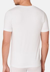 Weißes T-Shirt mit kurzen Ärmeln aus weichem Stoff. Verfügt über einen runden Halsausschnitt und ein schlichtes Design ohne sichtbare Nähte oder Muster.
