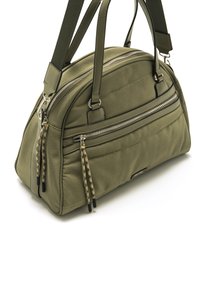 Sac à main vert olive avec deux poignées, en tissu texturé, plusieurs poches zippées et des pompons décoratifs sur les fermetures éclair. Vue de côté.
