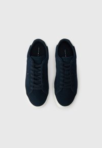 Zapatillas de ante azul marino con cordones planos y suela de goma blanca. Textura suave con acentos de costura y logo en la plantilla.