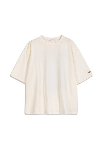 T-shirt en coton crème à manches courtes avec un col rond et un petit texte rouge sur le bord de la manche gauche.
