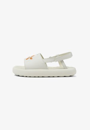 White sandals made of synthetic material, featuring a wide strap with orange stitching, an adjustable back strap, and a textured rubber outsole.