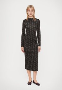 Zwarte midi-jurk met lange mouwen, voorzien van een bruin abstract patroon, gemaakt van rekbare stof met een slanke silhouette en een ronde halslijn.