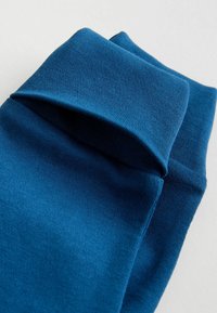 Blue cotton socks with a soft texture, featuring a folded cuff and seamless design for comfort.