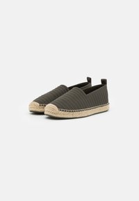 Espadrilky v tmavě zelené tkanině s prošívanou strukturou, juteová podrážka a elastické boky pro snadné obutí.
