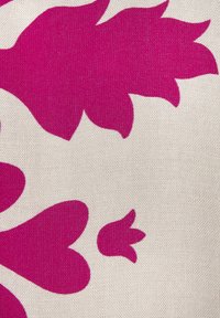 Stoff mit großen magentafarbenen Blütenformen auf einem hellbeigen Hintergrund, der eine glatte Textur und einen markanten Farbkontrast zeigt.