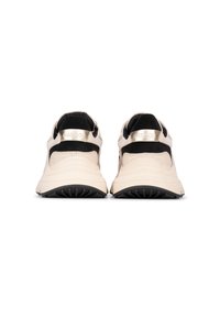 Sneaker beige e nere con tomaia testurizzata, collarino imbottito e suola in gomma prominente. Accento del logo metallico sul tallone.