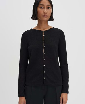 Cardigan lungo nero a maniche lunghe con un tessuto testurizzato, scollatura rotonda e chiusura frontale con sei bottoni bianchi.