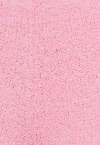 Roze terrycloth-stof met een zachte, gestructureerde oppervlak dat een donzig, lussenpatroon vertoont. Effen kleur en consistente textuur doorheen.