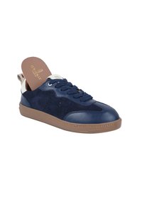 Sneaker blu navy con texture in pelle e camoscio, design con lacci, dettagli perforati sui lati e suola in gomma marrone chiaro.