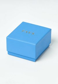 Blå fyrkantig låda med guldtexten "FAVS." på locket, placerad på en vit yta.