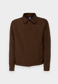 Veste légère marron avec un col, fermeture éclair à l'avant, poches latérales et bord élastique. Fabriquée en tissu lisse.