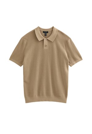 Polo à manches courtes beige en tissu côtelé. Il présente un col à revers, une patte à deux boutons et un ourlet droit.