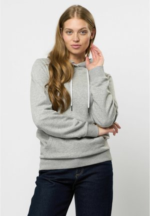 Grauer Hoodie mit Kängurutasche, gerippten Bündchen und Saum. Mit Kordelzügen und einem kontrastierenden Innenhalsdesign. Kombiniert mit dunklen Jeans.