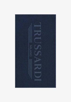 Tessuto rettangolare di colore blu scuro con "TRUSSARDI MILANO" stampato verticalmente in grandi lettere maiuscole azzurre con linee orizzontali.