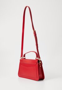 Röd läderhandväska med en strukturerad design, som har ett handtag upptill, justerbar axelrem och detaljer i guld.