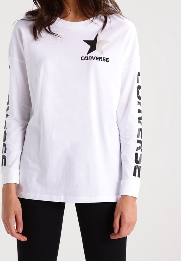 Biała bawełniana koszula z długim rękawem z czarnym logo gwiazdy oraz tekstem "CONVERSE" na rękawach w pogrubionej czarnej czcionce.