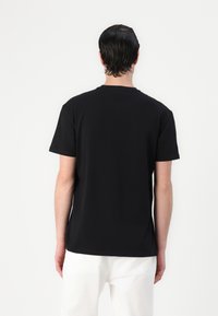Sort bomulds t-shirt med korte ærmer og rund halsudskæring, med en glat tekstur og en afslappet pasform. Ingen synlige grafik eller mønstre.