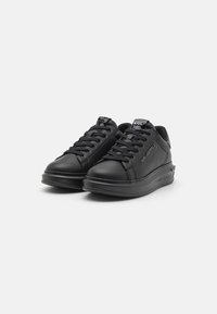 Sorte lædersneakers med rund tå, flad sål og traditionel snørring. Har logo-detaljer på siden og tungen. Glat overflade.