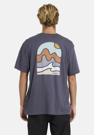 Grafitowy t-shirt z ciemnoniebieskiej bawełny, z kolorowym, abstrakcyjnym wzorem gór i fal na plecach oraz małym logo przy krawędzi.